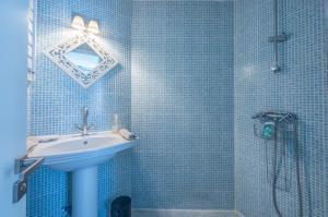 a blue tiled bathroom with a sink and a shower at Belle maison de pêcheurs Normande refaite par un architecte in Trouville-sur-Mer