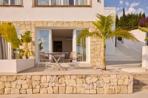 a patio with a table and a palm tree at Casa El Sueño in Jávea