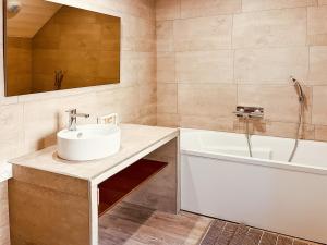 ein Badezimmer mit Waschbecken und Badewanne und Waschbecken in der Unterkunft Chez Madeleine, Entre le Lioran et Vic-sur-Cère in Thiézac + 12 Fotos