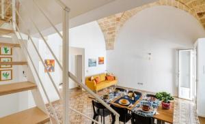 a living room with a table and a staircase at La casa dell' artista in Ugento