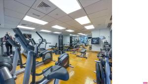 ドバイにあるKing 1BR Apartment With Burj Khalifa & Fountain Viewのトレッドミルやカーディオマシンが並ぶジム