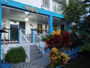 a house with blue trim and flowers on the stairs at Posada Miss Portia in Providencia