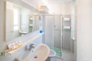 a white bathroom with a shower and a sink at Ambra Hotel Cattolica in Cattolica +67 photos