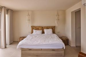 a bedroom with a large bed with white sheets and pillows at Casa El Sueño in Jávea