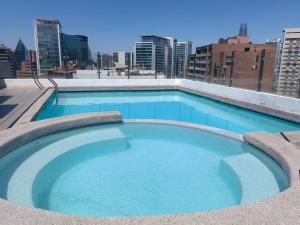 a swimming pool on the roof of a building at Apart Barrio El Golf con piscina in Santiago