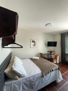 a bedroom with a bed and a desk and a table at Pousada Ponta Mar in Natal +42 photos
