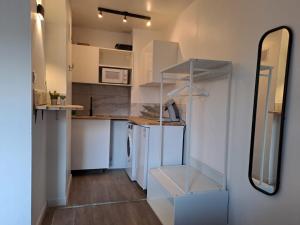 a small kitchen with white cabinets and a mirror at Lafayette Gare Saint-Charles in Marseille