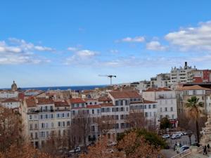 a city with buildings and the ocean in the background at Lafayette Gare Saint-Charles in Marseille