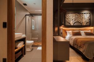 a bedroom with a bed and a bathroom with a sink at Mater Hotel in Canela +87 photos