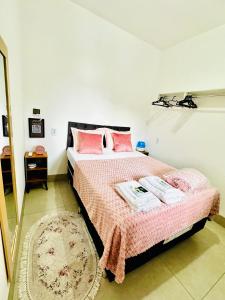a bedroom with a bed with pink sheets and a mirror at Apartamento aconchegante in Nova Mutum +28 photos