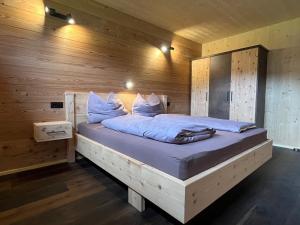 a bedroom with a bed in a wooden wall at Lärchenchalet am Weißensee in Oberdorf
