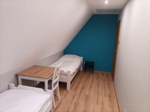 a small room with two beds and a table at Domek nad potokiem in Tylicz