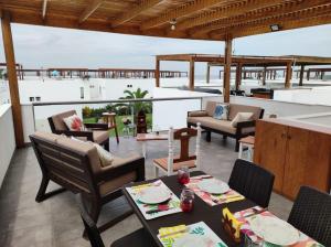 a patio with a table and chairs on a balcony at Casa en condominio de playa para 12 personas, Asia in Rosario de Asia