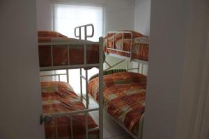 three bunk beds in a room with a window at Casa en condominio de playa para 12 personas, Asia in Rosario de Asia