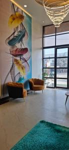 a lobby with chairs and a large painting on the wall at BlueNeck Ayodhya-Near ShriRam Mandir in Ayodhya