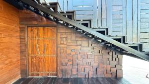 a wooden door on a building with a staircase at Kawarin River Exclusive Hotel & Resort in Ban Gaeng Cho