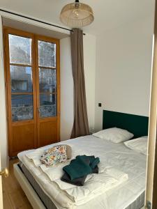 a bedroom with a white bed with a window at Appartement de la côte in Murol