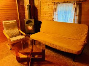a couch and a chair in a room with a stove at Na samotě u lesa in Vsetín