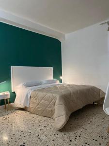 a bedroom with a large bed with a green wall at La Bouganville B&B in Sora