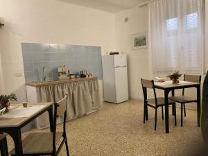 a kitchen with a white refrigerator and tables and chairs at La Bouganville B&B in Sora