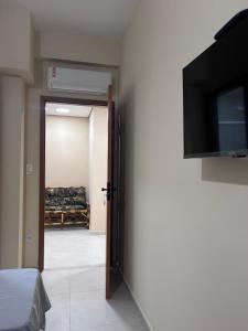 a room with a door with a flat screen tv at Pousada Beata Francisca de Paula in Aparecida