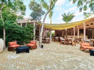 un patio con mesas y sillas y una tienda de campaña en luxury Penthouse Tulum, en Tulum