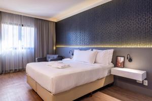 a hotel room with a large bed and a chair at Intercity São Paulo Berrini in São Paulo