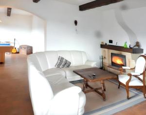 a living room with a white couch and a fireplace at Villa spacieuse à Cannes-et-Clairan avec piscine privée in Cannes-et-Clairan
