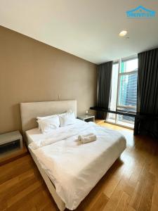 Un dormitorio con una cama grande con sábanas blancas. en Platinum KLCC 2BR by Dream Inn, en Kuala Lumpur