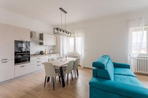a living room with a table and a blue couch at Arya's Corner by the Lake - Parcheggio - Vista lago in Arona