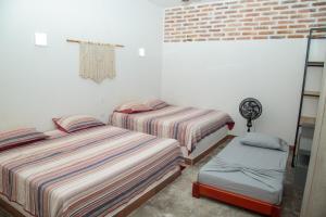 a bedroom with two beds and a chair in it at Hacienda San Nicolas -Pto Boyaca in Puerto Triunfo