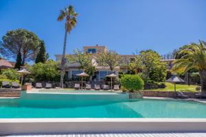 a swimming pool in front of a house at Résidence Les Toits de Santa Giulia in Porto-Vecchio