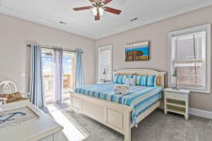 a bedroom with a bed and a ceiling fan at Ocean Charm in North Topsail Beach