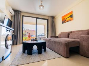 una sala de estar con un sofá y una mesa en Appartement résidence, en Taghazout