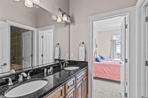 a bathroom with two sinks and a bedroom at Ocean Charm in North Topsail Beach +44 photos