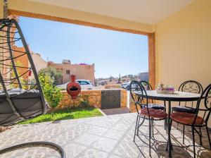 Un patio con mesa y sillas y un columpio. en Appartement résidence, en Taghazout