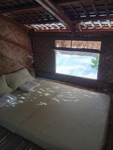 a large bed in a room with a window at El Hermosa Beach Resort in El Nido