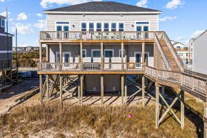 a large house with a deck on the beach at Ocean Charm in North Topsail Beach