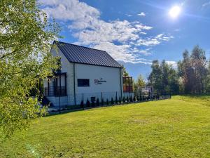a white building with a grassy field in front of it at Kazimierska Oaza in Kazimierz Dolny
