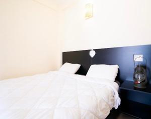 Un dormitorio con una cama blanca con una pared azul. en Appartement résidence, en Taghazout 36 fotos más