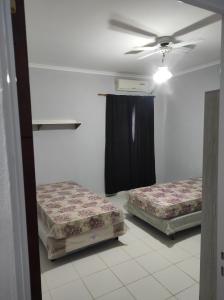 a room with two beds and a ceiling fan at El ceibo in Camba Punta