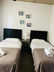 two beds sitting next to each other in a room at Los plátanos 1 y 2 in Junín +11 photos