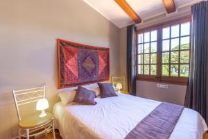 a bedroom with a bed and a painting on the wall at Ca la Goyi in Caldes de Malavella +37 photos