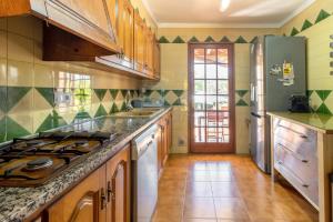 a kitchen with wooden cabinets and a counter top at Ca la Goyi in Caldes de Malavella