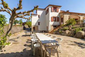 a row of tables and chairs in front of a house at Ca la Goyi in Caldes de Malavella