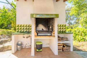 a outdoor pizza oven with a fireplace on a patio at Ca la Goyi in Caldes de Malavella