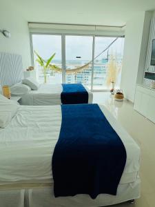 three beds in a room with a large window at Cartagena in Cartagena de Indias