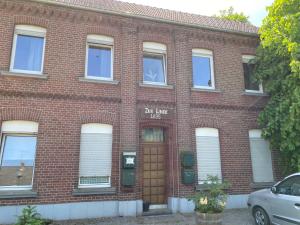 a red brick building with a brown door at Worker Space Bedburg Hau in Bedburg Hau