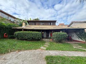 a house with a grass yard in front of it at Casa Mágica in Praia do Rosa