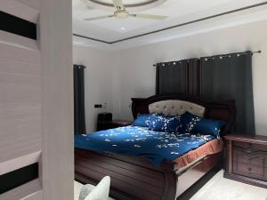 a bedroom with a bed and a ceiling fan at T-Roys Apartments in Accra